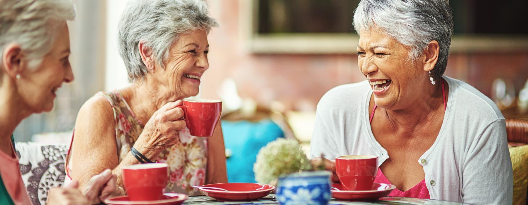 a group of old women sitting at a table with tea cups